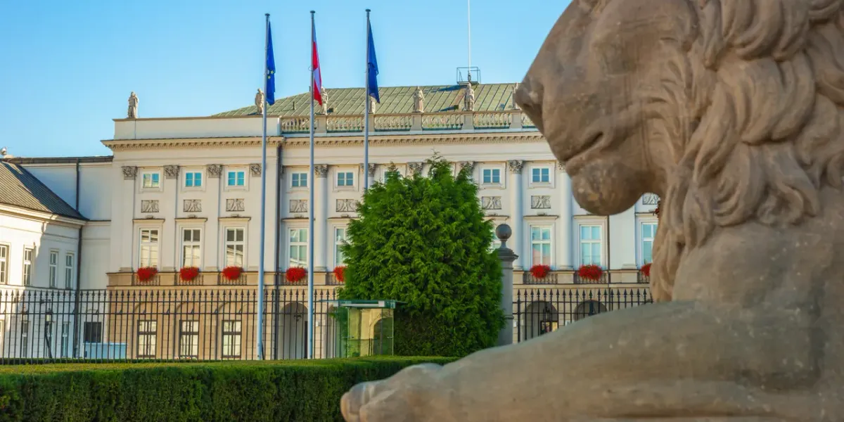 Reprezentacyjny gmach z pomnikiem lwa i polską flagą w Warszawie
