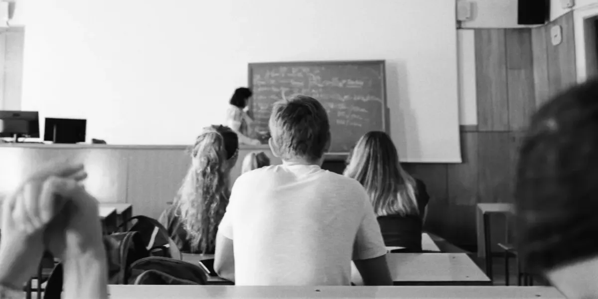 Czarno-białe zdjęcie studentów siedzących w sali wykładowej