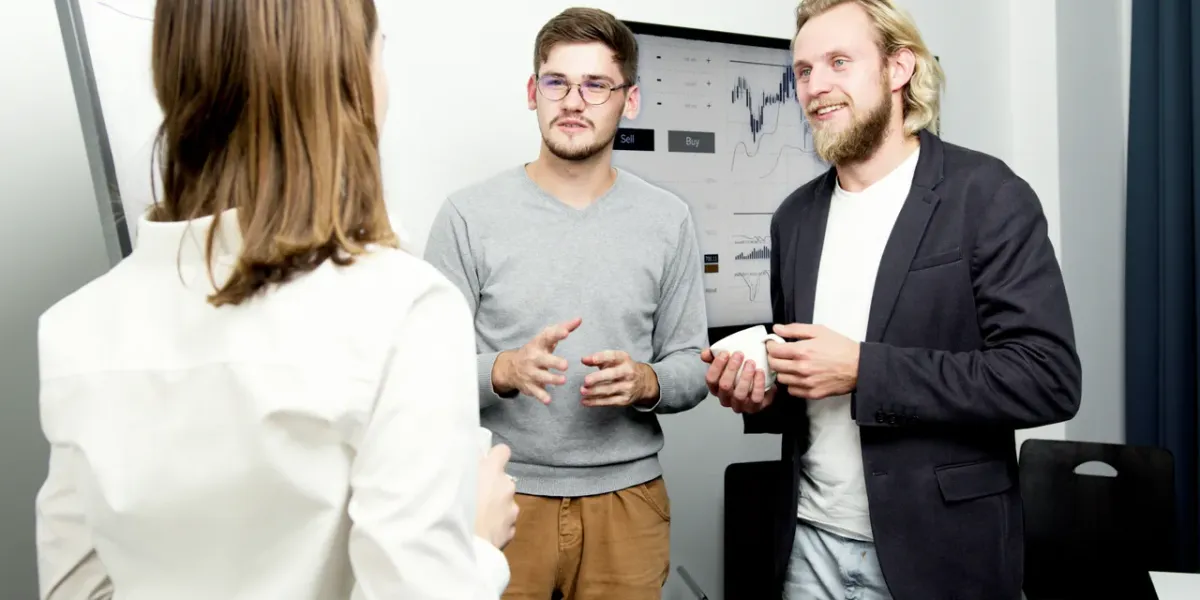 Dwóch studentów omawiających dane finansowe przy tablicy z wykresami