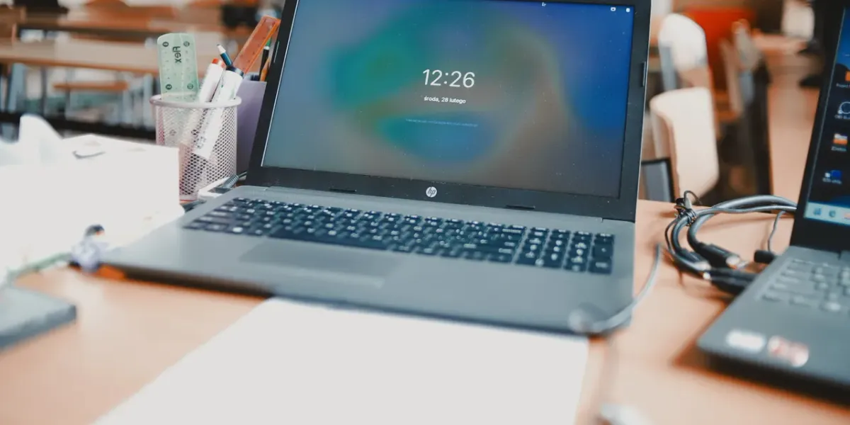 Laptop na biurku szkolnym w sali komputerowej