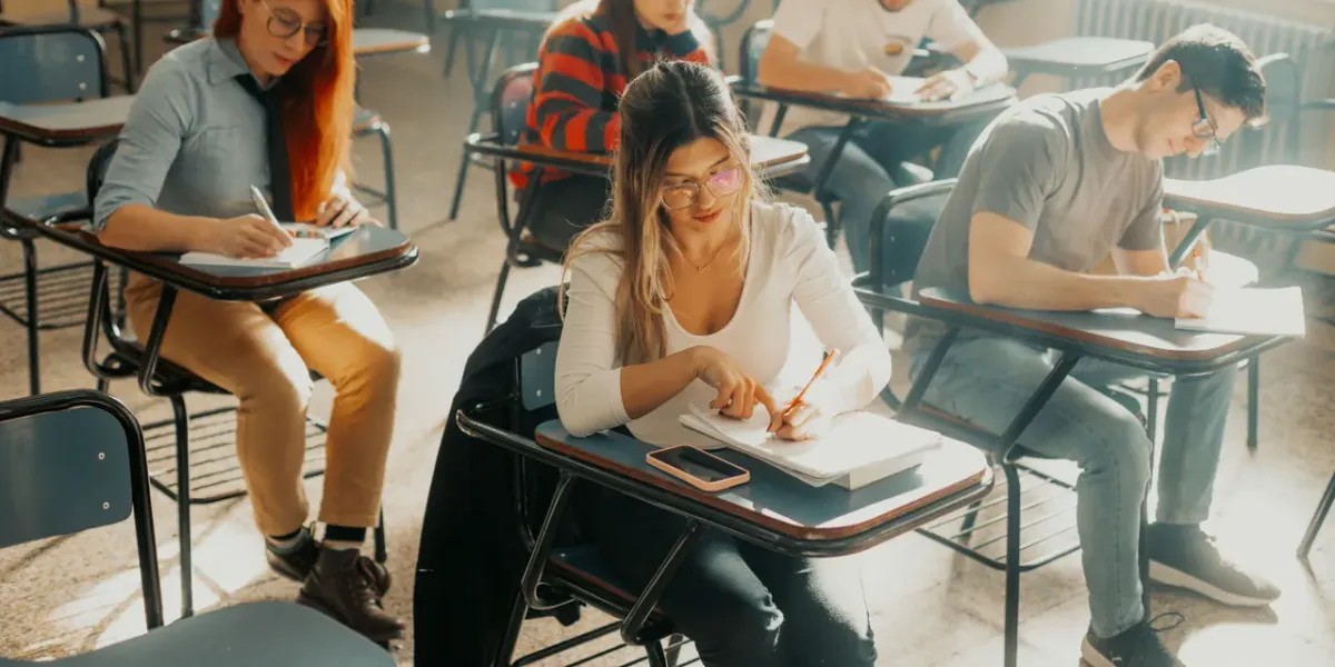 Studenci piszący egzamin w sali wykładowej