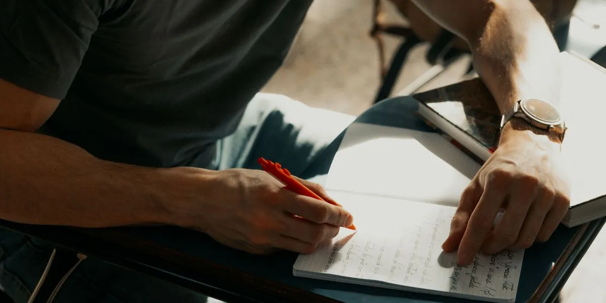 Student robiący notatki przy biurku