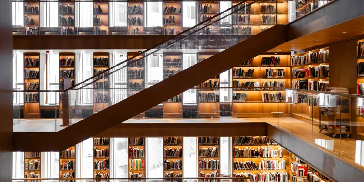 Nowoczesne, wielopiętrowe wnętrze biblioteki uniwersyteckiej z regałami książek