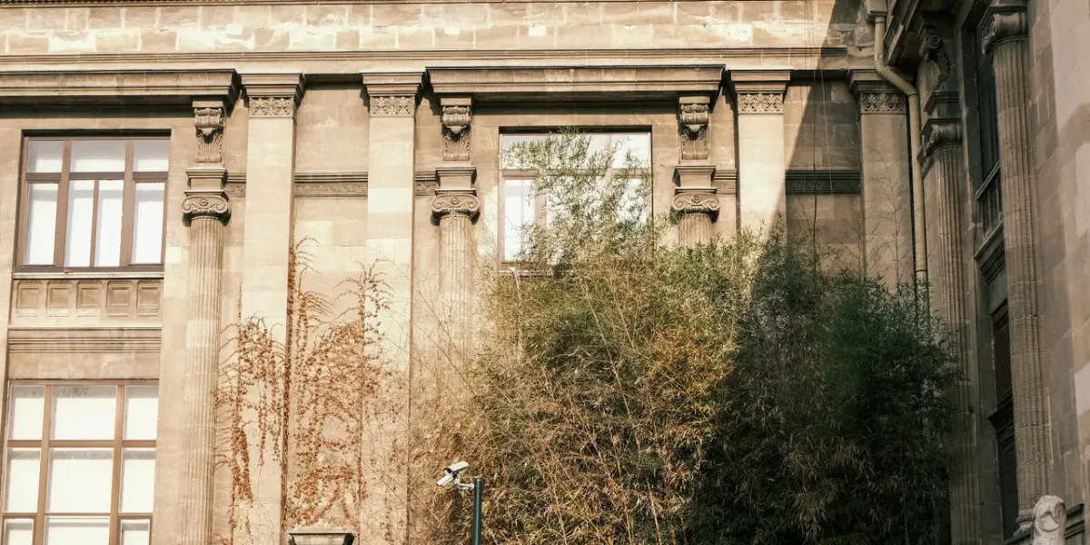 Fasada zabytkowego budynku uczelni z jesiennymi pnączami