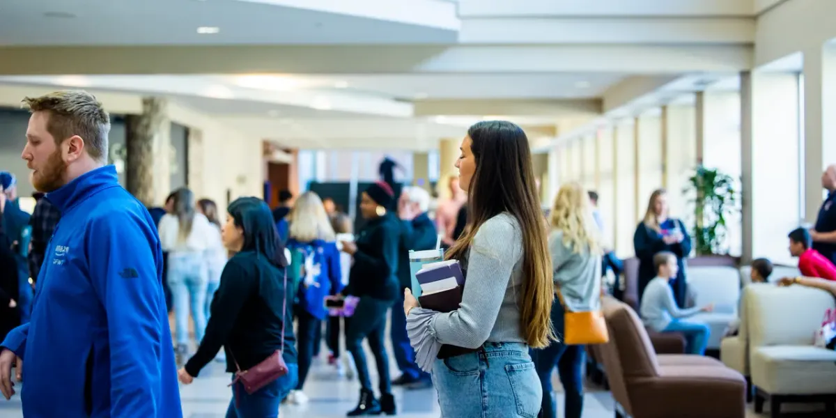 Zatłoczony korytarz kampusu uniwersyteckiego pełen studentów
